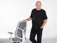 man-standing-next-to-office-chair