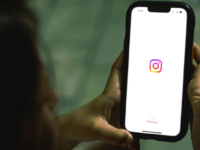 Woman holding iPhone with instagram logo on screen