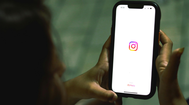 Woman holding iPhone with instagram logo on screen