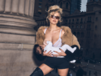 Woman by column posing in underwear and fur coat breastfeeding baby