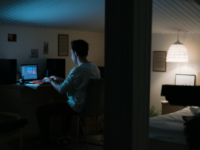 Man working on a laptop at nighttime.