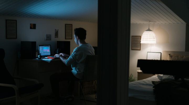 Man working on a laptop at nighttime.