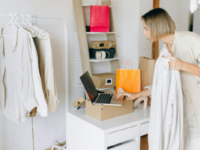 Woman working in fashion shop using laptop