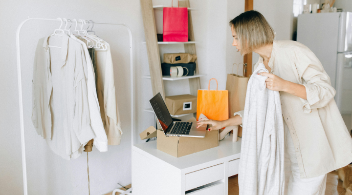 Woman working in fashion shop using laptop