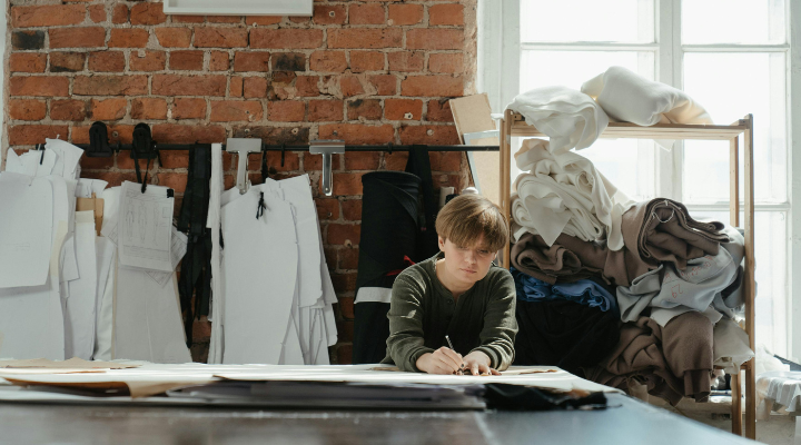 A woman designing clothes in a studio.