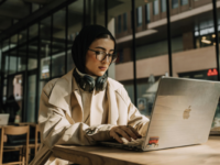 Woman working on laptop in coworking space.