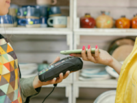 Side view of woman tapping eftpos reader with phone.