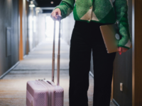 Woman with suitcase and laptop.